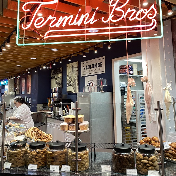 Termini Bros. neon sign over counter of baked items and icing bags at Reading Terminal Market in Philadelphia